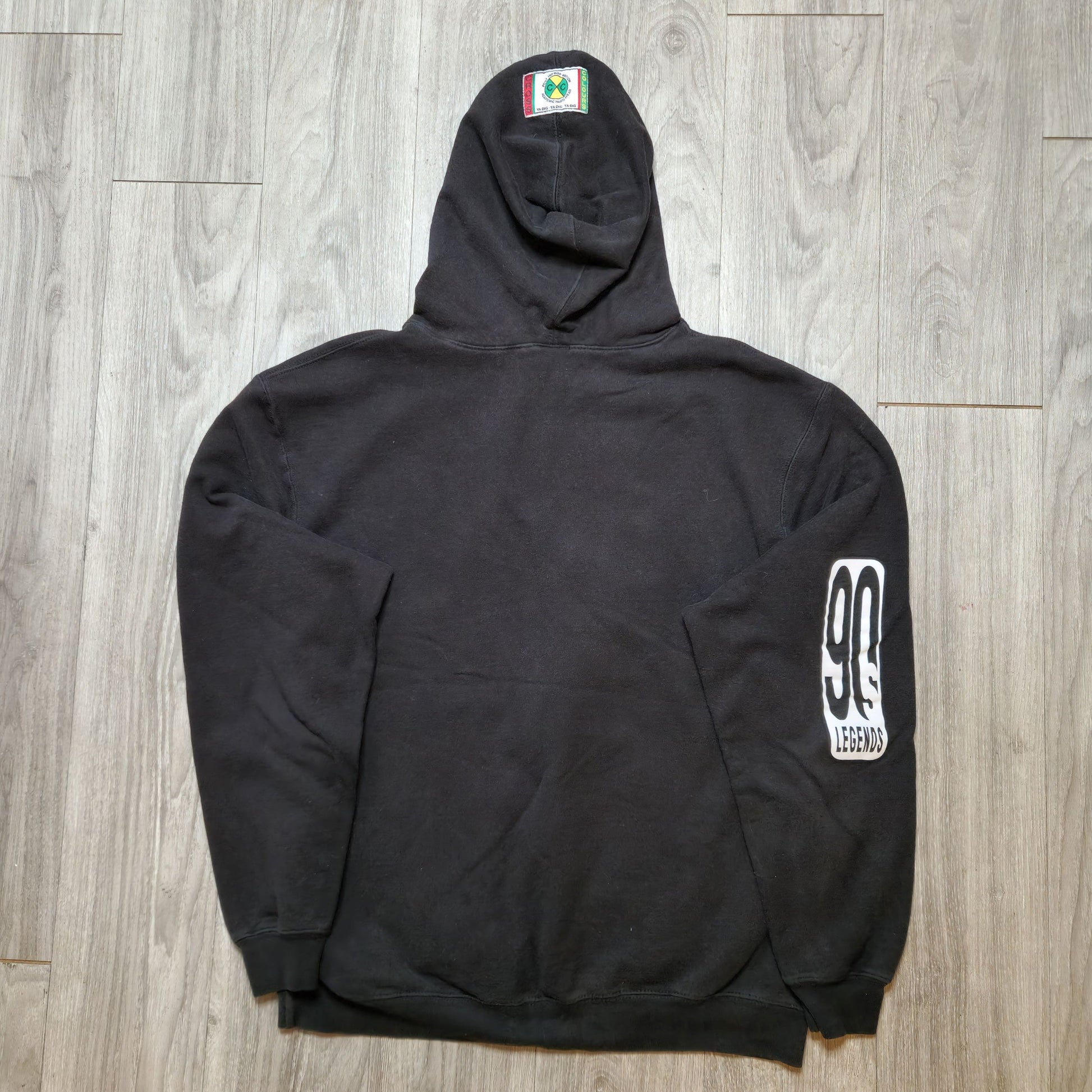 Black hoodie with logos on a wooden floor